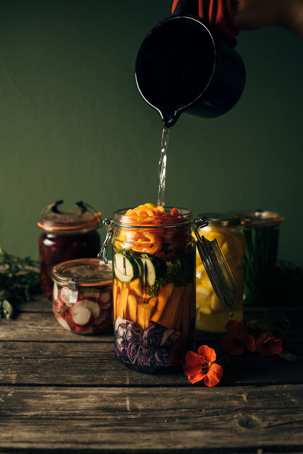 Conservare le verdure: si versa liquido in un barattolo con verdure colorate tagliate