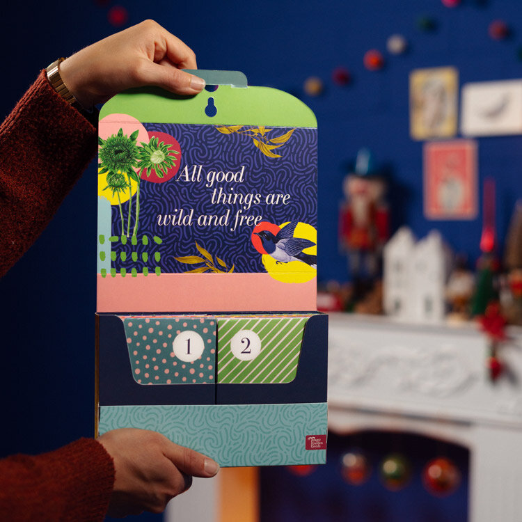 Calendario dell’Avvento di semi «Ortaggi, erbe & fiori» aperto con le bustine 1 e 2, tenuto in mano